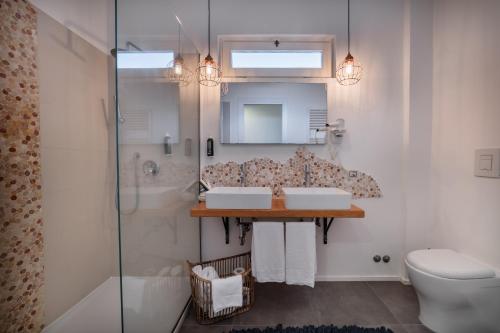 a bathroom with two sinks and a shower at Lula Hotel - Ex Love & Fama Hotel in Sabaudia