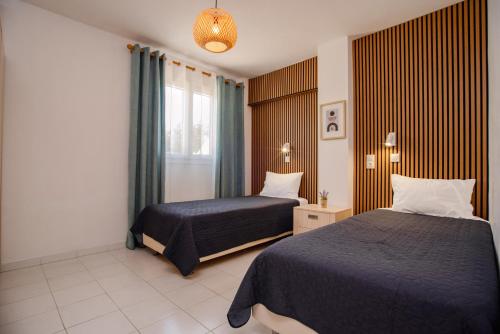 a hotel room with two beds and a window at Roys Blu in Kavos