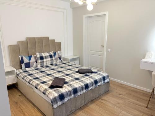 a bedroom with a bed with a checkered blanket at Cosy luxury apartament in Baia Mare