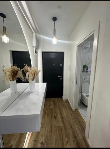 a living room with a white table and a black door at Cosy luxury apartament in Baia Mare