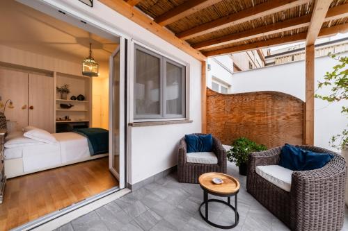 a room with a balcony with a bed and chairs at Lula Hotel - Ex Love & Fama Hotel in Sabaudia