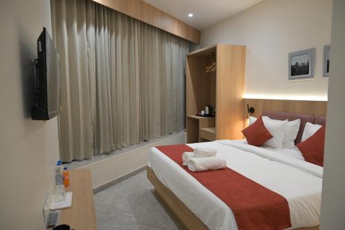 a hotel room with a bed and a television at The Bhavani Hotel in Dāhod
