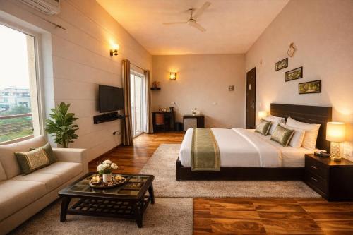 a hotel room with a bed and a couch at Onyx Suite Luxury Apartment # Lift # Garden # Ac rooms # Private Parking # Near Prem Mandir # Located Inside- Omaxe Eternity Vrindavan # in Vrindāvan