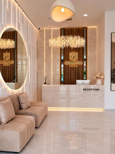 a lobby with a couch in front of a reception at Golden Nina Hotel in Vlorë
