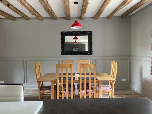 a dining room with a table and chairs and a mirror at The Old Post Office Gite -Jouac in Jouac