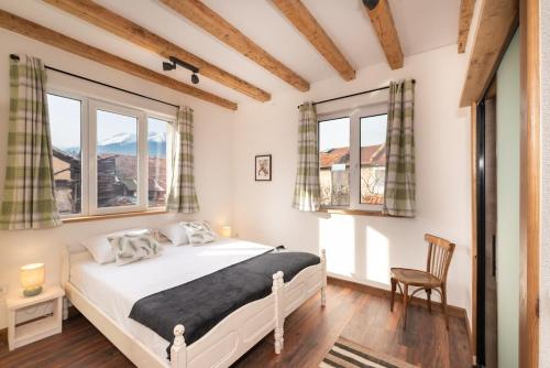 a bedroom with a bed and two windows at Chalet Firefly in Bansko