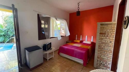 a bedroom with a bed and a tv in it at Châle guesthouse in Paracuru