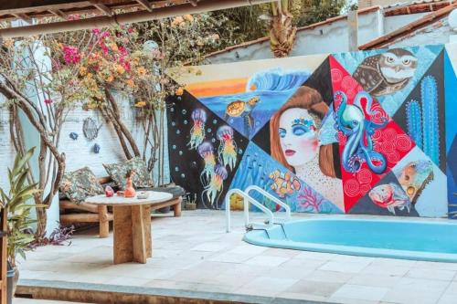 a mural on a wall next to a pool at Pousada Zayon Jeri in Jericoacoara