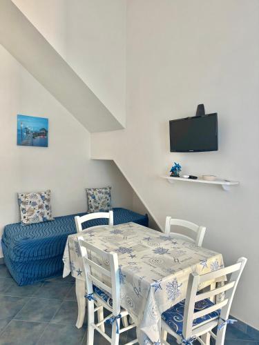 a dining room with a table and chairs and a couch at L'angolo blu in Marettimo