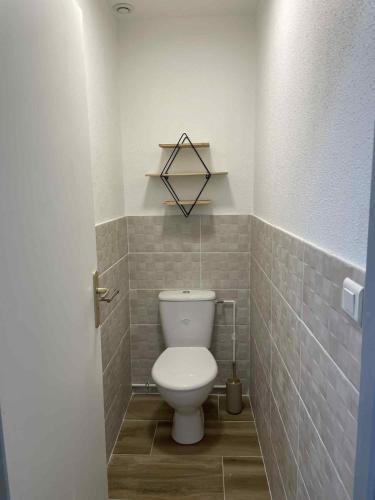a bathroom with a toilet in a tiled room at Appartement à Vouglans in Lect