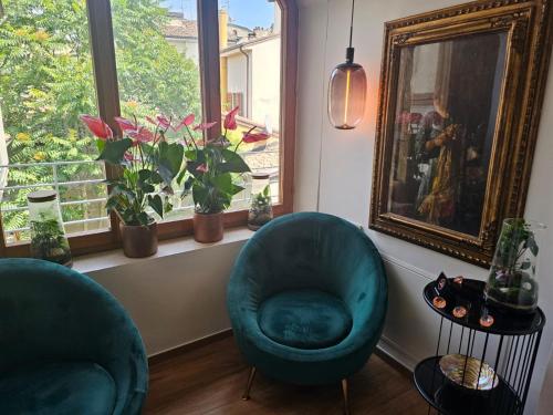a living room with two chairs and a window at Salotto Corso Garibaldi in Piacenza