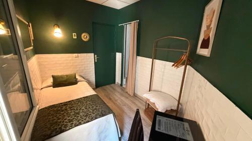 a room with two beds and a green wall at Hotel Comédie - Place De La Comédie Opéra in Montpellier