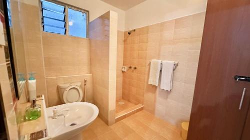 a bathroom with a sink and a toilet and a shower at Mtwapa Beach Nest D3 in Mtwapa