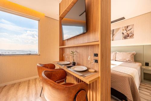 a bedroom with a bed and a desk with a mirror at Flat Premium Design Moderno, Completo in Osasco