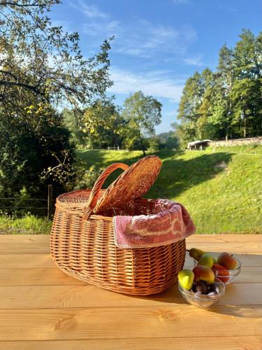 a basket of bread and a bowl of fruit on a table at Glamping Zeleni raj Vače in Vače