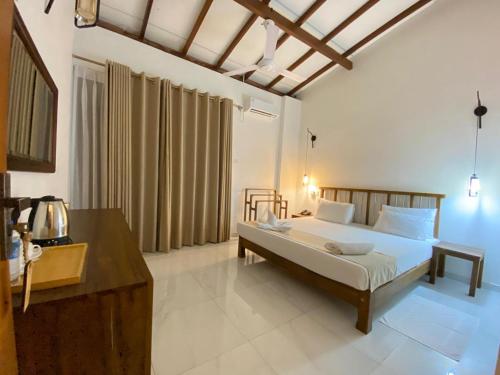 a bedroom with a bed and a desk in it at River Tree Bolgoda in Panadura