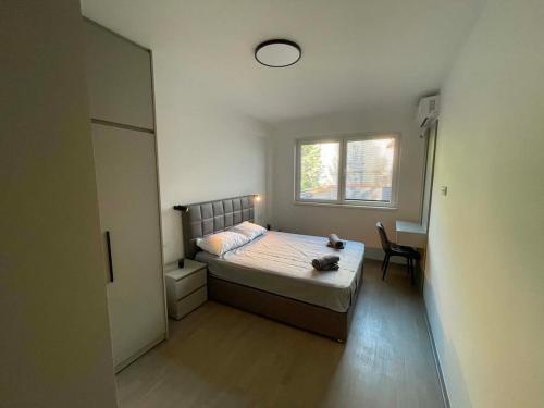 a bedroom with a bed and a desk and a window at BD Luxury Apartment in Bitola