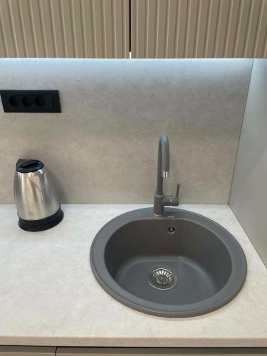 a kitchen counter with a sink with a faucet at BD Luxury Apartment in Bitola