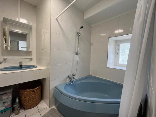 a bathroom with a blue tub and a sink at Maison CALI LUZ in Luz-Saint-Sauveur