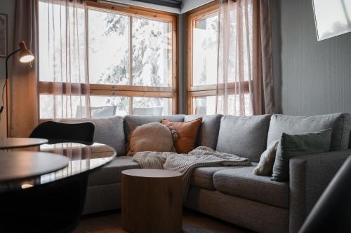 a living room with a gray couch with pillows at Rinneköngäs - Ruka-Pyhä 2x SKIPASS included - Free Skibuss Doorstep - Renovated in Ruka