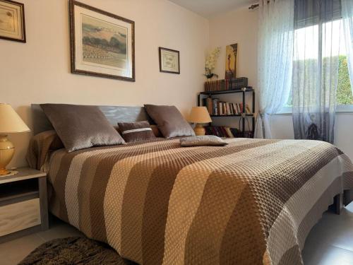 a bedroom with a bed with a striped comforter at Chambre d'hôtes in Montauban