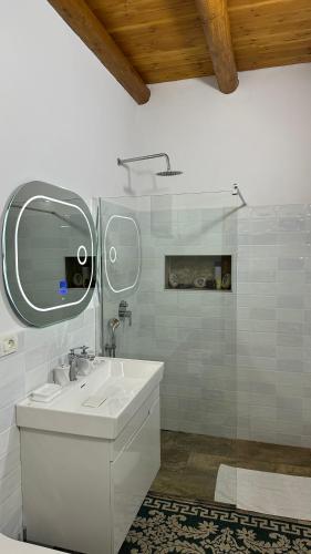 a white bathroom with a sink and a mirror at Vila Ramaj in Berat