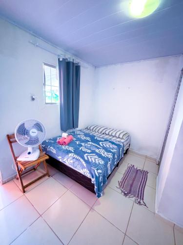 a small bedroom with a bed and a fan at Suítes Jacumã in Conde