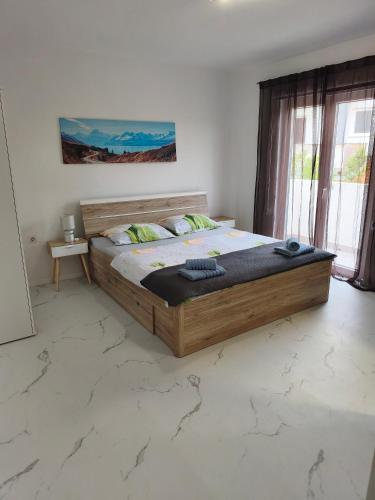 a bedroom with a large wooden bed in a room at Apartments Luka in Rab