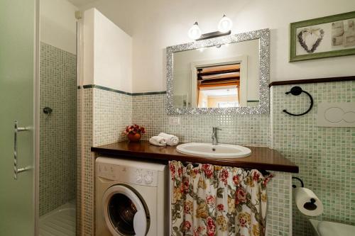 a bathroom with a sink and a washing machine at Appartamento Caretto in Baveno