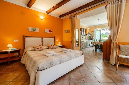 a bedroom with a large bed with orange walls at Appartamento Caretto in Baveno