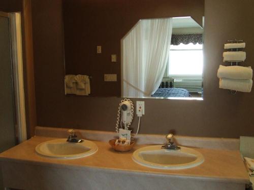 a bathroom with two sinks and a mirror at Ponderosa Motor Inn in Golden