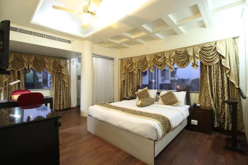a bedroom with a bed and a large window at The Nagpur Ashok in Nagpur