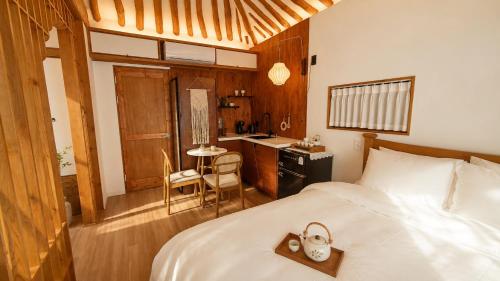 a bedroom with a bed and a desk and a kitchen at Hanokstay mokhwa in Gyeongju