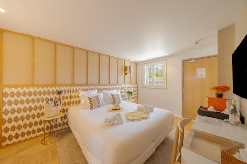 a bedroom with a large white bed and a desk at Lou Saint-Tropez in Saint-Tropez