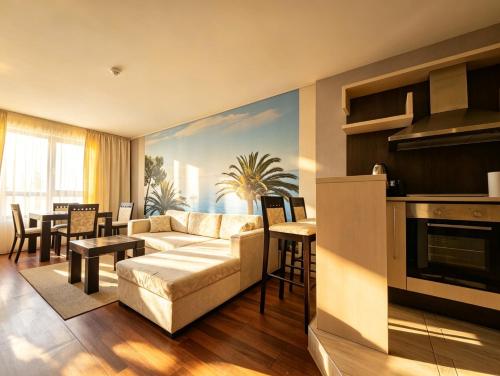 a living room with a couch and a dining room at Europroperties Zlatna Kotva Apartments in Golden Sands