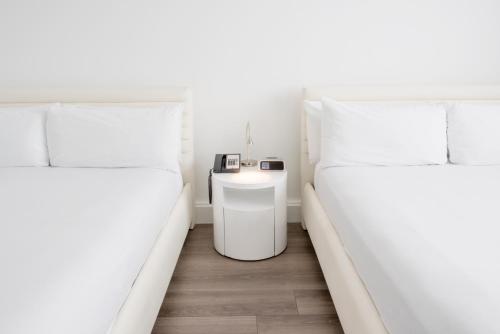 two beds in a small room with a table between them at President Hotel in Miami Beach