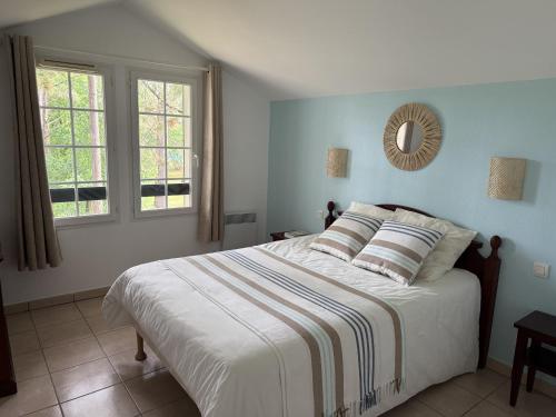 a bedroom with a bed and a mirror on the wall at Superbe appartement 6 personnes in Biscarrosse