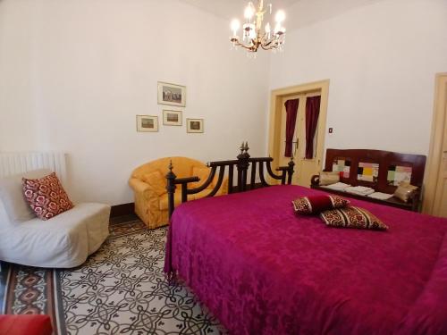 a bedroom with a large bed and a chair at Guesthouse City Center in Bari