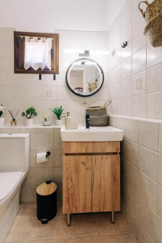 a bathroom with a sink and a mirror at Rustic Kampos House Retreat in Chios