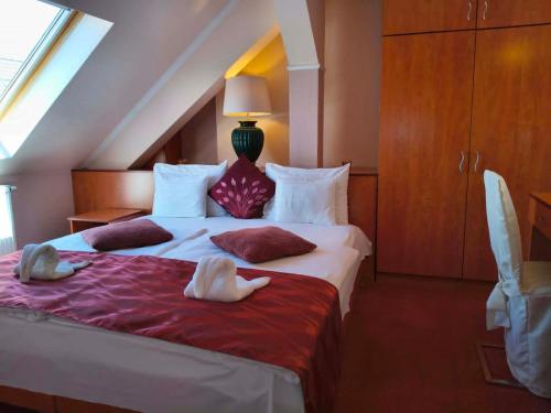 a bedroom with a large bed with towels on it at Hotel Isabell Győr in Győr