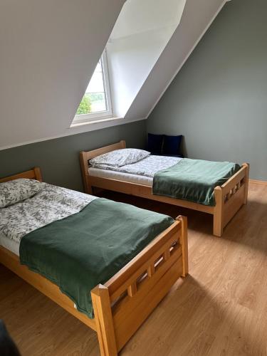 a bedroom with two beds and a window at Willa nad stawem in Mezowo