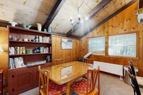 a dining room with a wooden table and chairs at 7 Merrimeeting Chalet in Conway