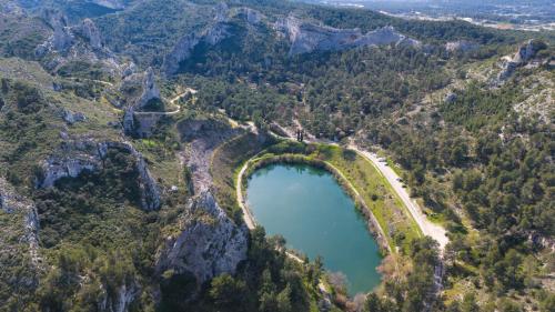 an aerial view of a lake in the mountains at Camping de la Vallée Heureuse in Orgon