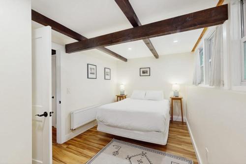 a bedroom with a white bed and wooden ceilings at 7 Merrimeeting Chalet in Conway