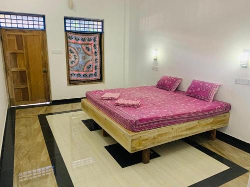 a bed in a room with a purple mattress at Laughing Leopard Trinco in Trincomalee
