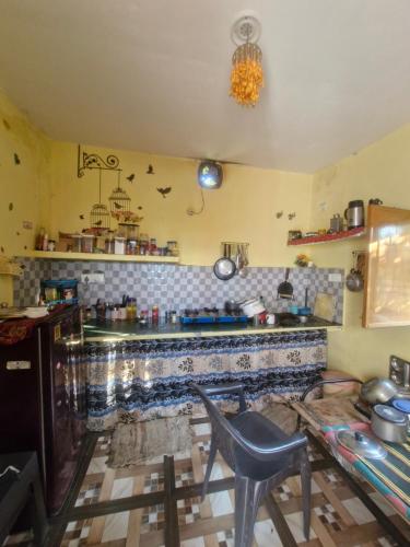 a kitchen with a table and a counter top at Far out Homestay in Hawālbāgh