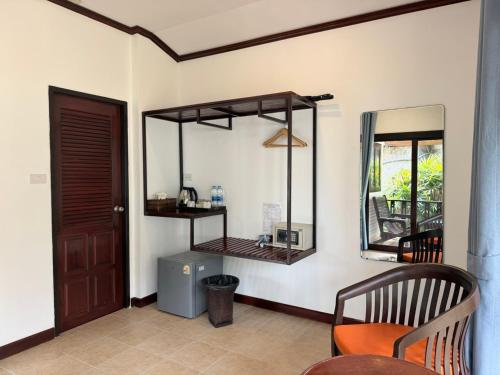 a room with a mirror and a chair and a door at Am Samui Resort Taling Ngam in Taling Ngam Beach