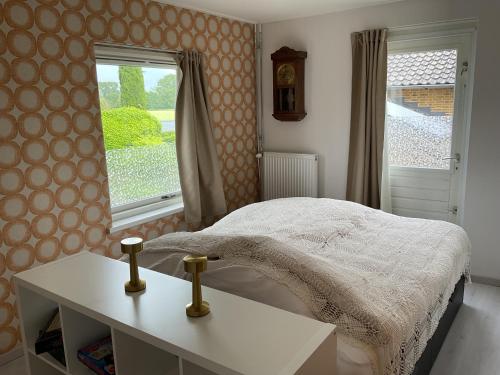 a bedroom with a bed and a table and a window at Bed en Brood Prunushof in Zelhem