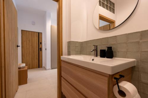 a bathroom with a sink and a mirror at Asini deluxe suite 4, with rooftop terrace and breathtaking views in Asíni