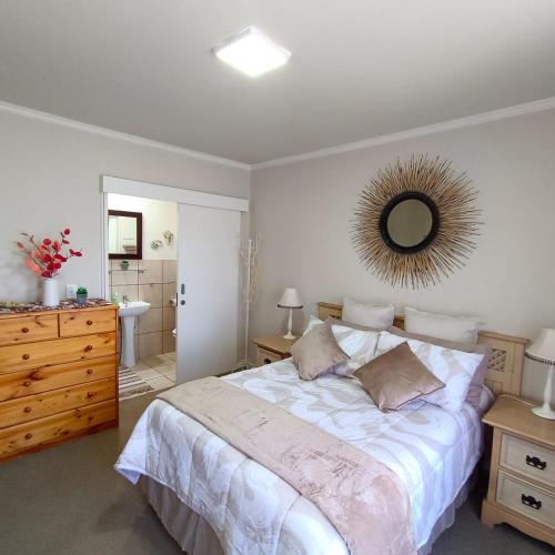 a bedroom with a bed and a mirror on the wall at Heaven at Sea in Mossel Bay